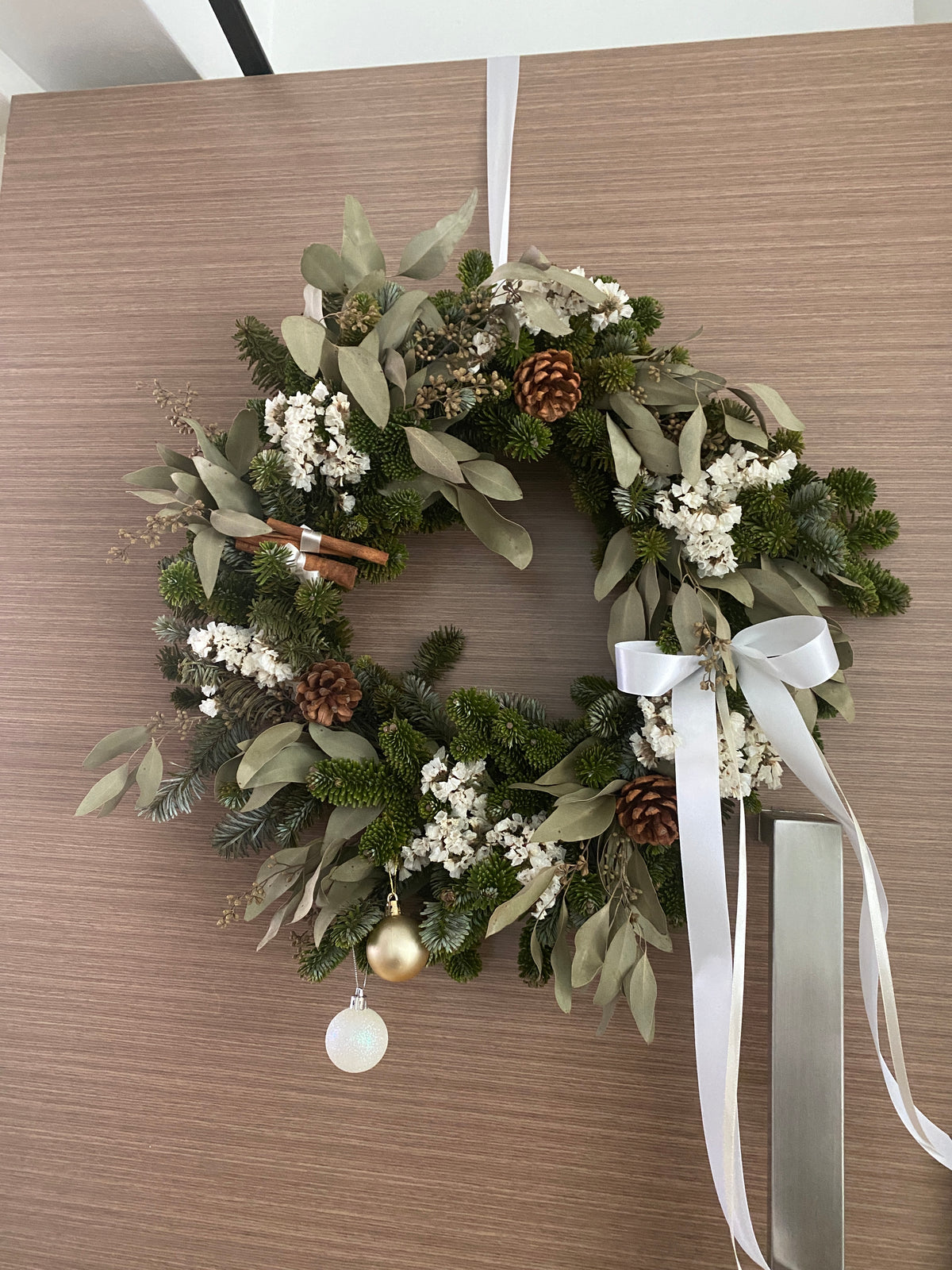 Fresh Christmas Wreath, decorated with baubles, ornaments, cotton, pinecones, cinnamon sticks and more by Eden's Ground, a Floral Design Studio in Singapore.
