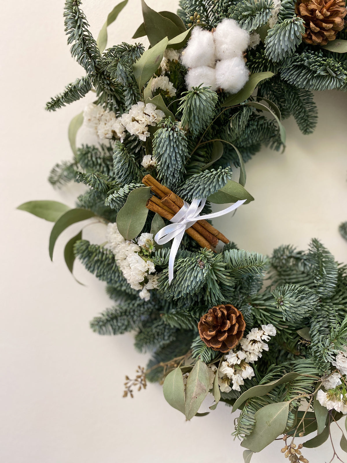Fresh Christmas Wreath, decorated with baubles, ornaments, cotton, pinecones, cinnamon sticks and more by Eden's Ground, a Floral Design Studio in Singapore.