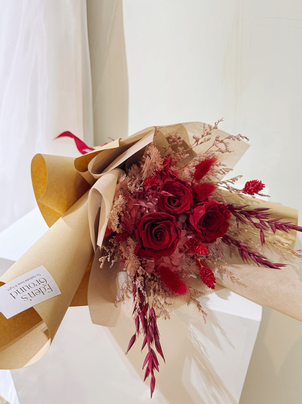 For Valentine's Day 2027, Eternal valentine bouquet made with all shades of red to symbolise deep love, surrounded by textural foliage, wrapped in tissue paper and kraft paper, crafted by Eden’s Ground. Delivered straight to your doorstep.