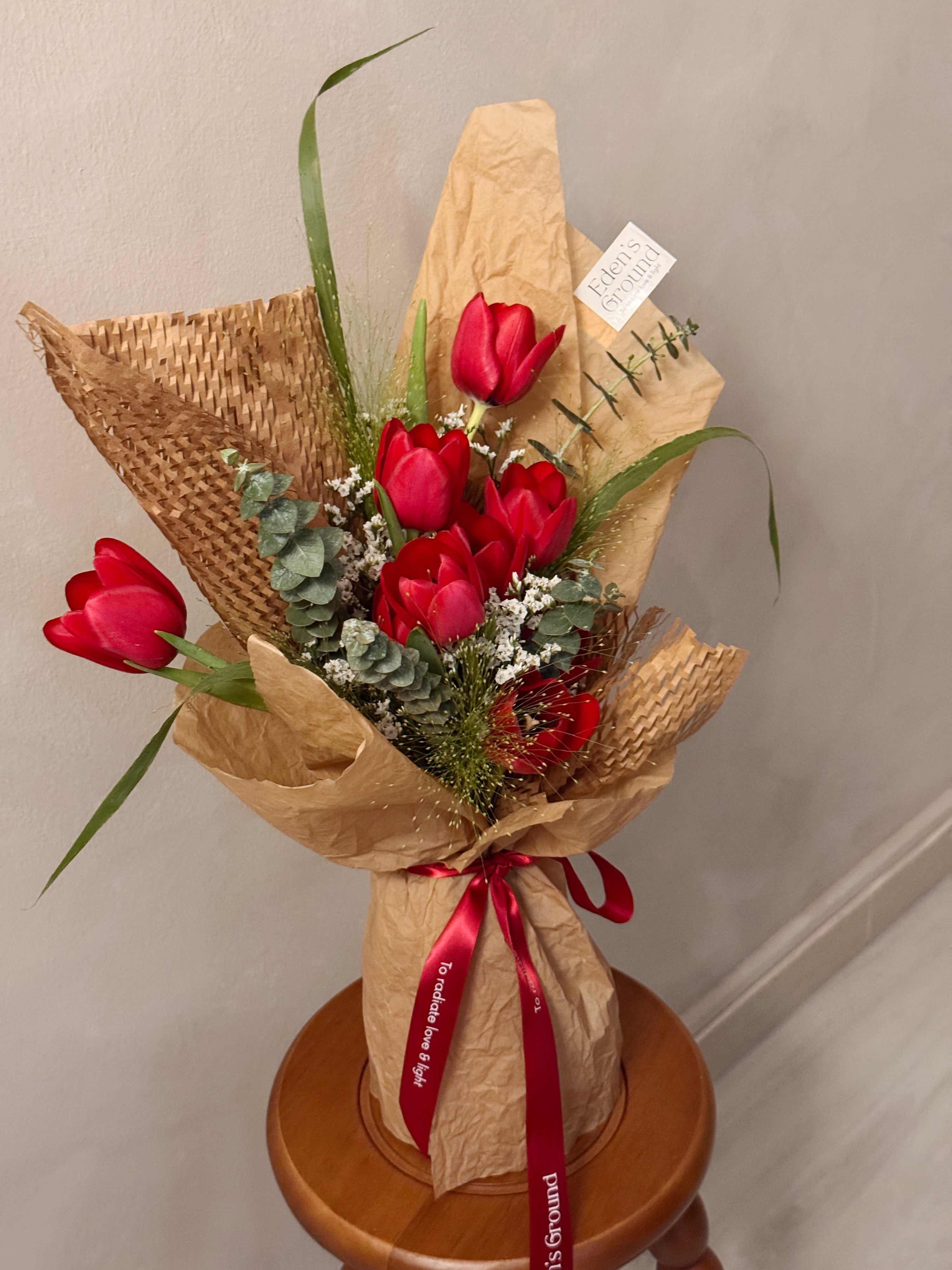 Sweetest Love bouquet featuring vibrant red tulips with lots of textural foliage such as eucalyptus, wrapped in brown honeycomb and kraft paper crafted by Eden’s Ground, a floral design boutique based in Singapore.