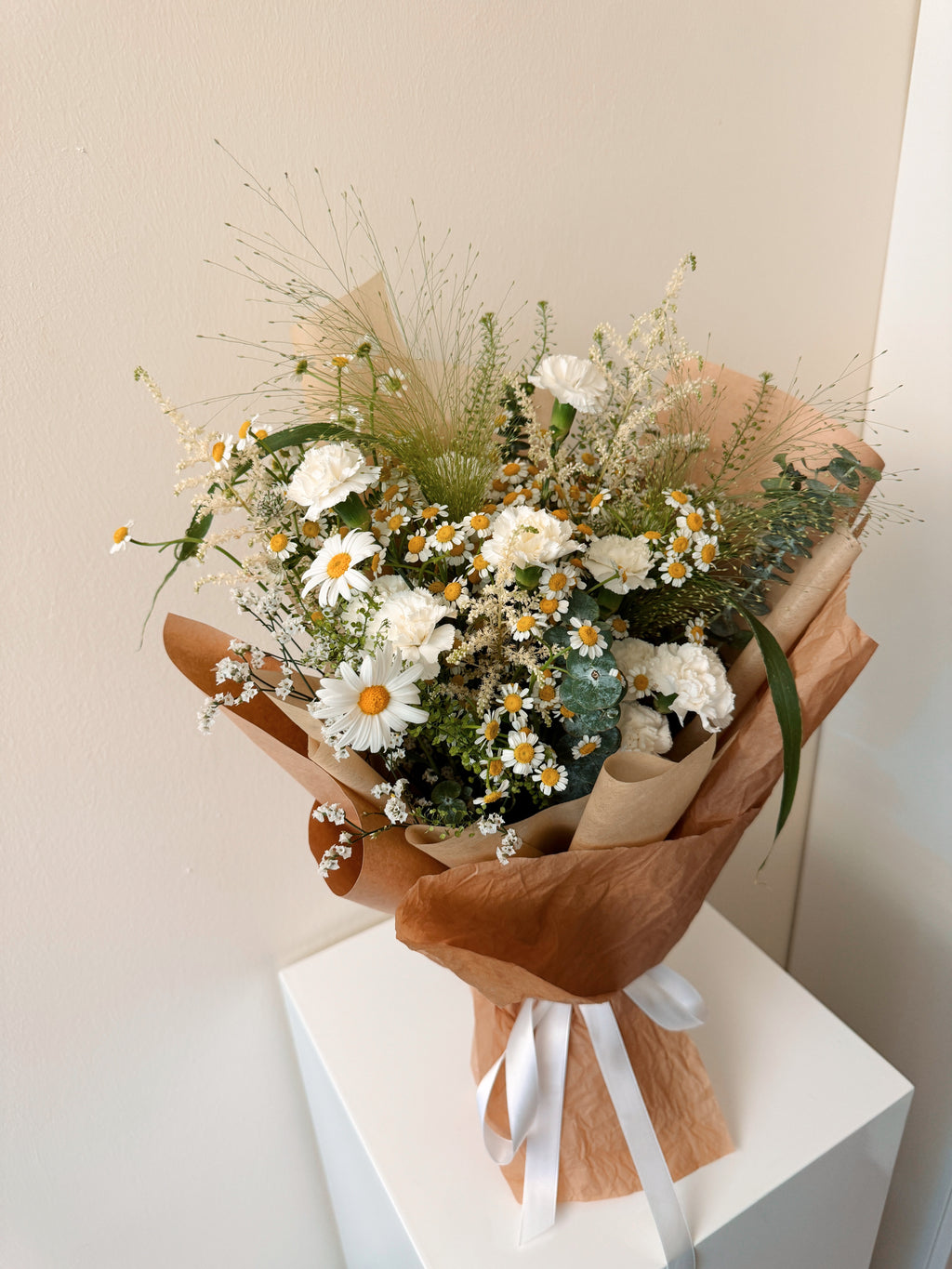 Wildflowers Musings featuring nature-inspired chamomile daisies with lots of textural foliage such as eucalyptus, wrapped in tissue paper and brown kraft paper crafted by Eden’s Ground.